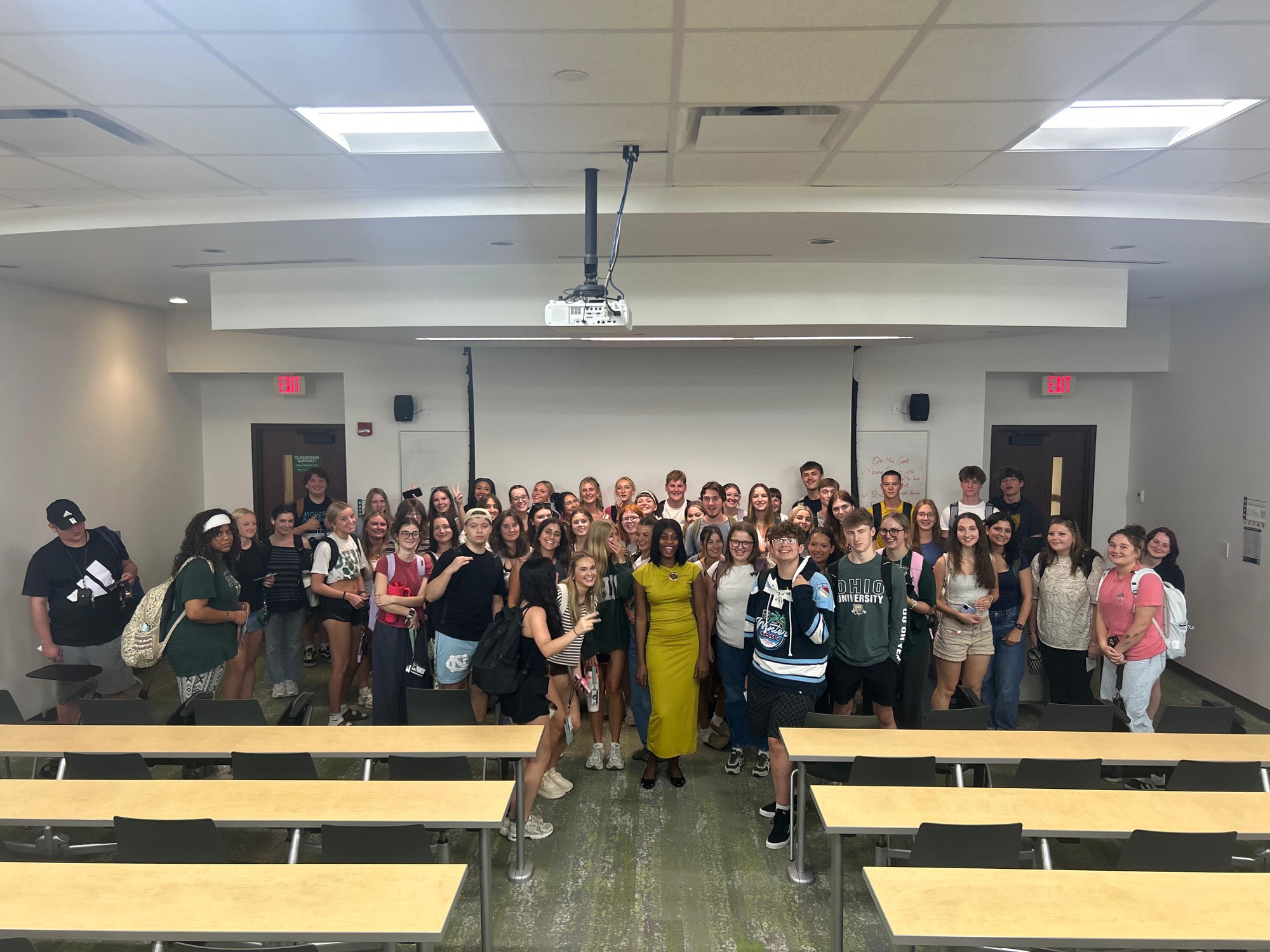 Christabel standing with a large group of students in a university classroom